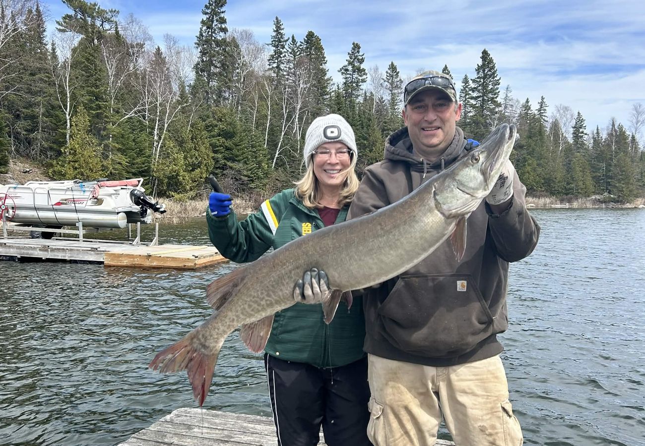 Two anglers on the dock with a big springtime muskie
